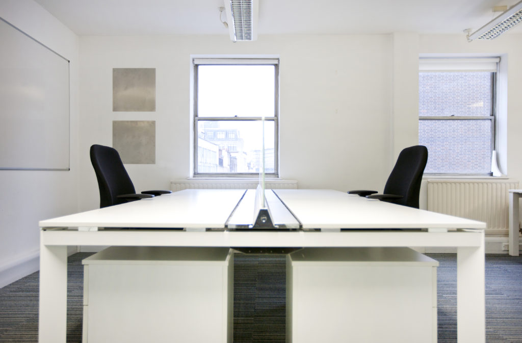 Empty office desks back to back